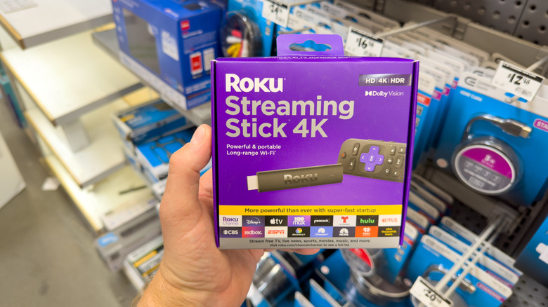 A shopper holding Roku Streaming Stick 4K in a store