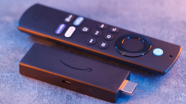 An Amazon Fire TV Stick on the carpet with its remote