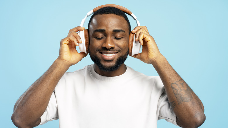 Man wearing over-the-ear headphones and smiling