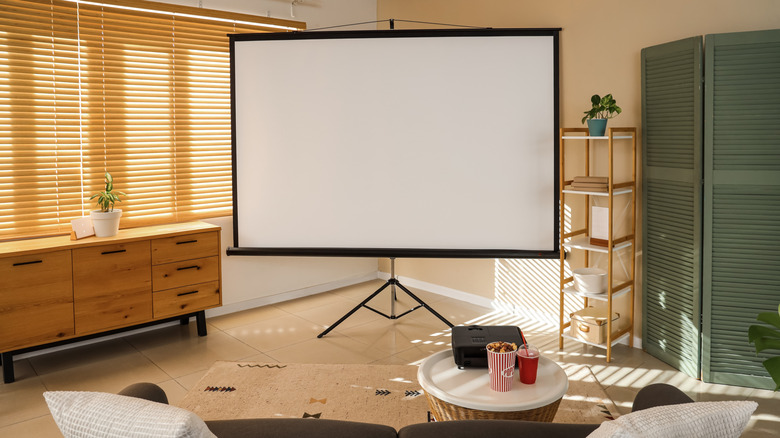 A home theater setup, including a projector and screen, and popcorn.
