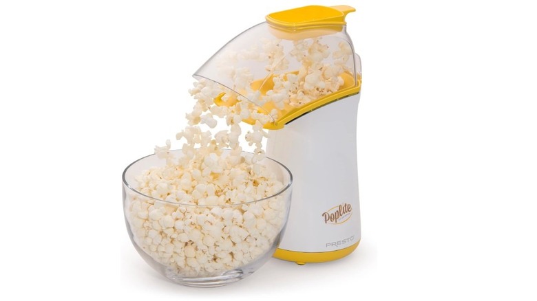 Presto Hot Air Popcorn Popper dispensing freshly popped popcorn into a glass bowl.