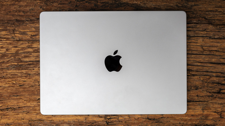 A Grey MacBook laying on a wooden table