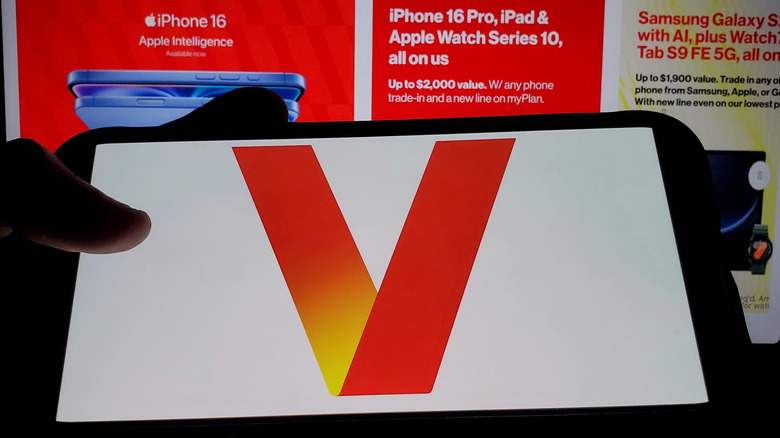 Verizon logo on smartphone with company webpage in the background