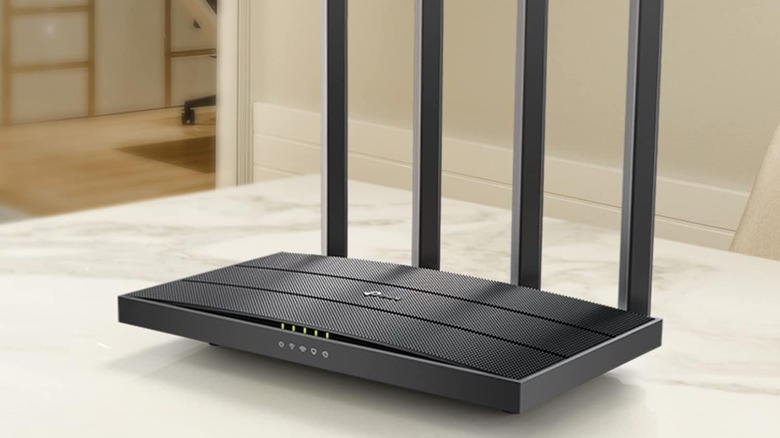 A TP-Link AC1200 gigabit router sits on a counter top in a house.