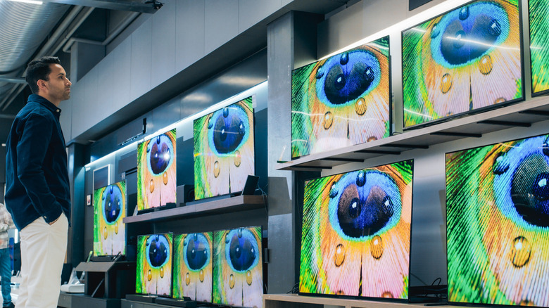 Buyer taking a look at smart TVs on display in a store