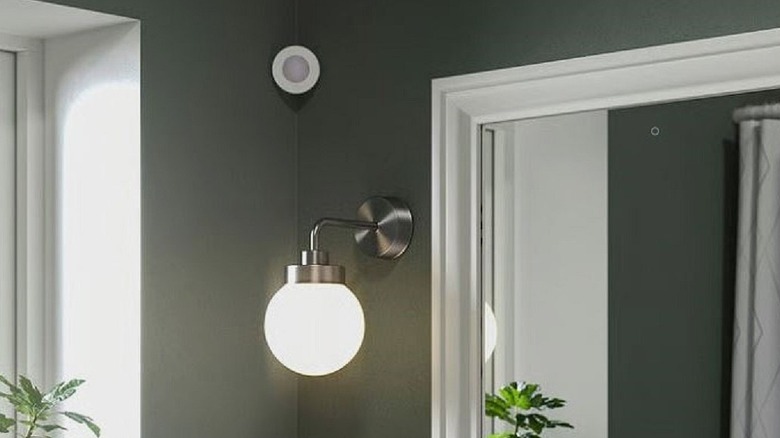An IKEA Myggspray wireless motion sensor installed in the corner of a bathroom for lighting automation.