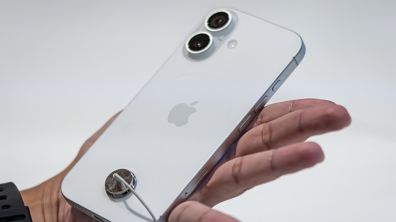 A customer holding an iPhone 17 in an Apple Store
