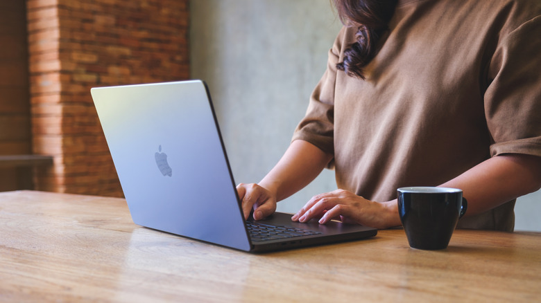 Using a MacBook Pro alongside a cup of coffee