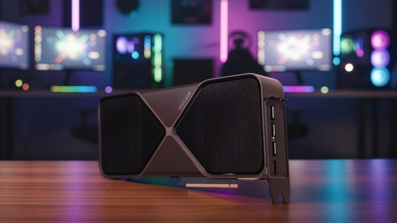 Nvidia RTX 5090 graphics card resting on a desk with RGB-lit gaming setup in the background
