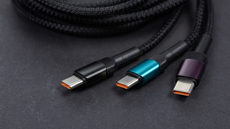 Three thunderbolt or USB-C cables coiled up and sitting on a surface