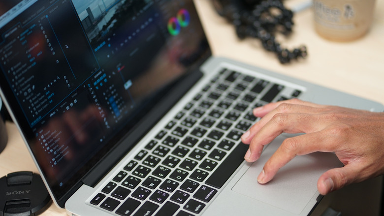 A person using a laptop with a Final Cut Pro project on the screen