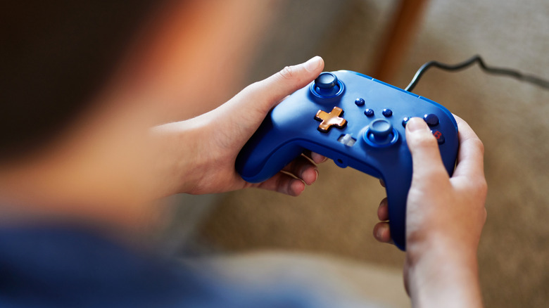 A close-up of a blue controller being held in hands