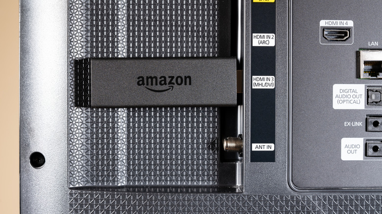 Amazon Fire TV streaming stick inserted in HDMI socket on SmartTV