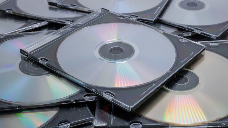 CDs and DVDs in clear plastic cases piled on top of one another