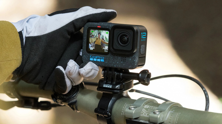 Bicyclist adjusting GoPro on bike frame