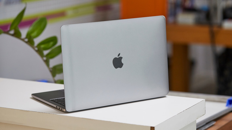 A MacBook sitting on a white counter, the back of the machine is facing the camera