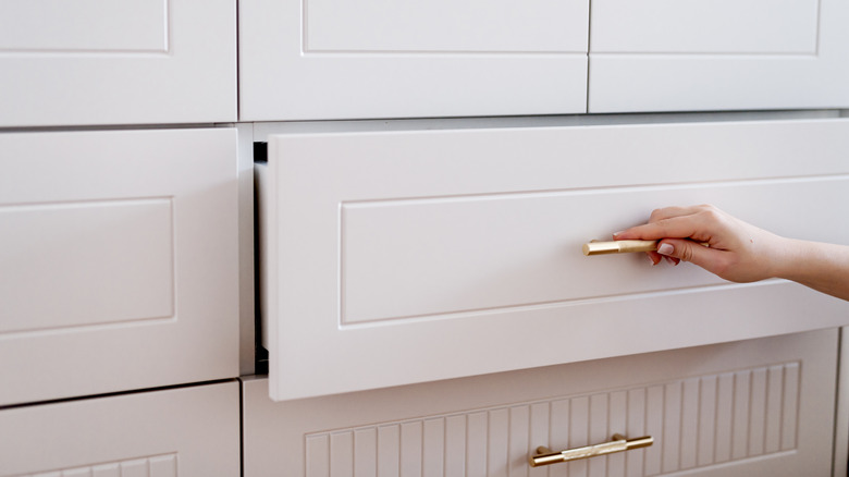 a hand pulling open a drawer
