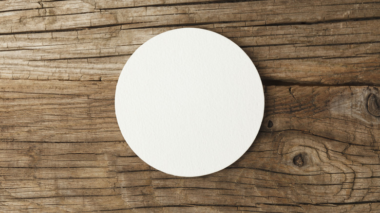 Circular drink coaster on wooden surface