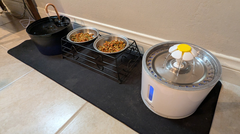 A gaming mouse pad with cat food and water bowls sitting on it