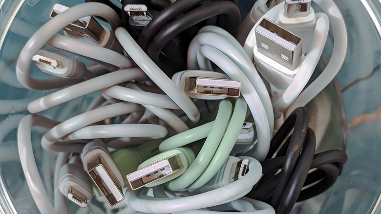 multicolored charging cables placed inside a transparent container