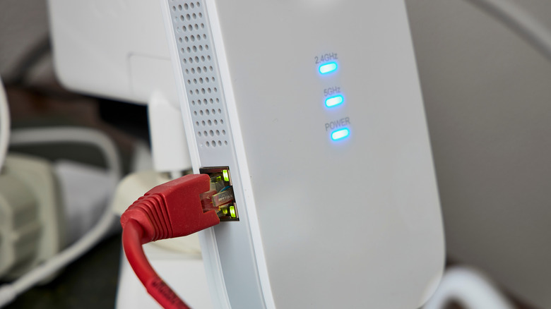 Close-up image of a wi-fi extender device plugged into an ethernet cable
