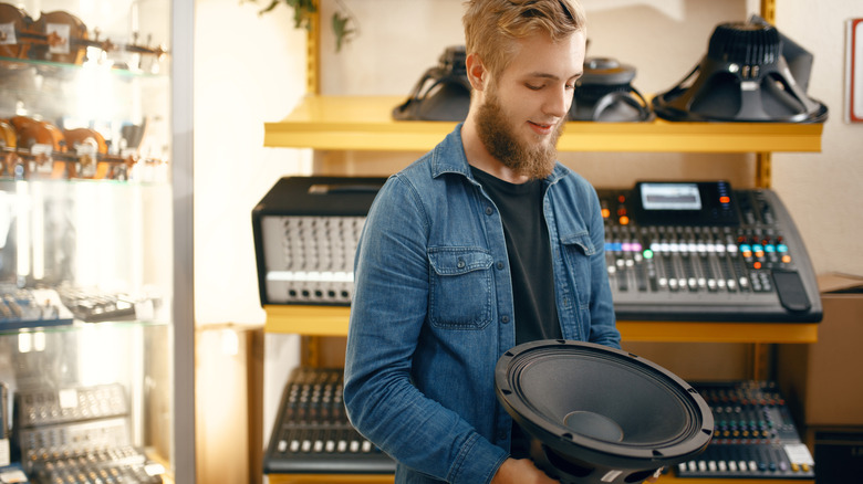 Man inspecting a subwoofer in a store