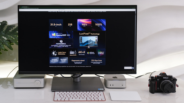 Workspace with a monitor, Mac, camera, and other accessories