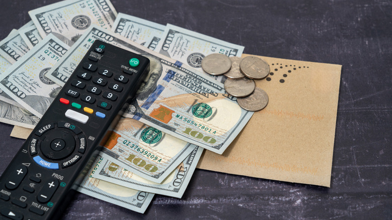 TV remote on top of pile of money
