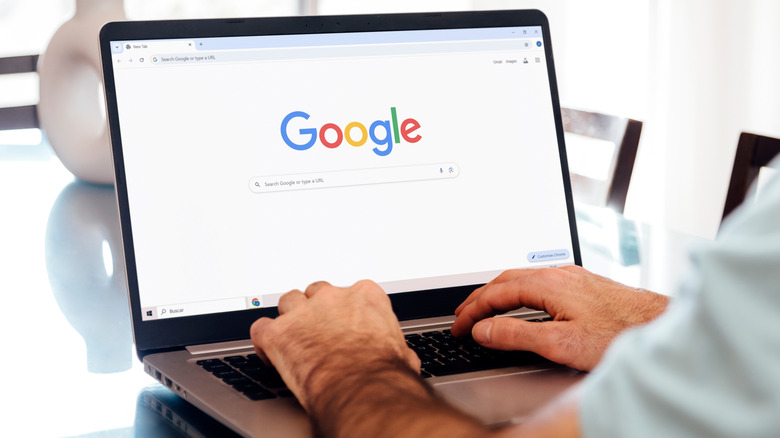 person working on a laptop with the Google homepage open