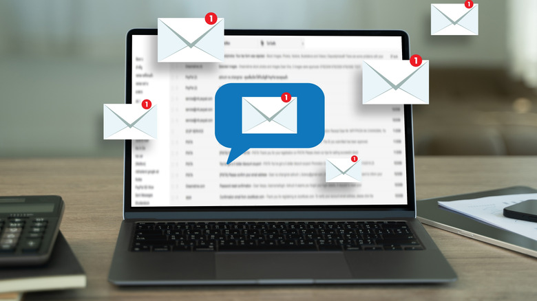 laptop placed on a table with envelope and email graphics over the screen