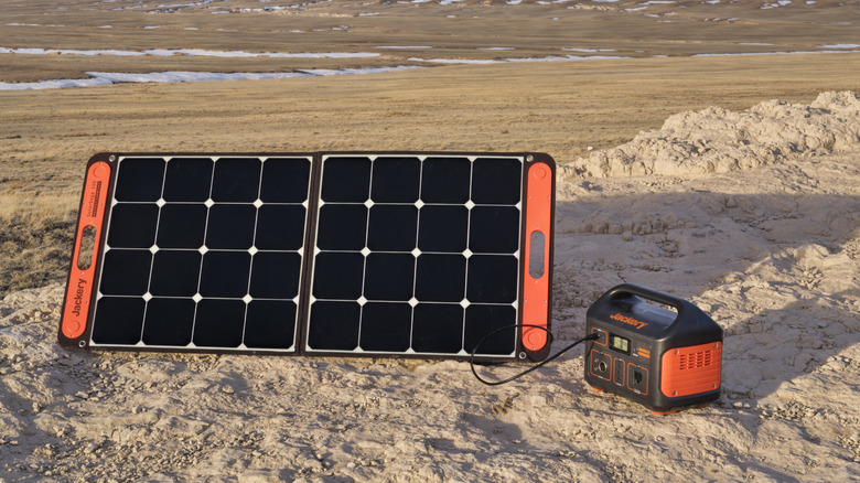 Jackery solar generator and power station with a small portable solar panel outdoors.