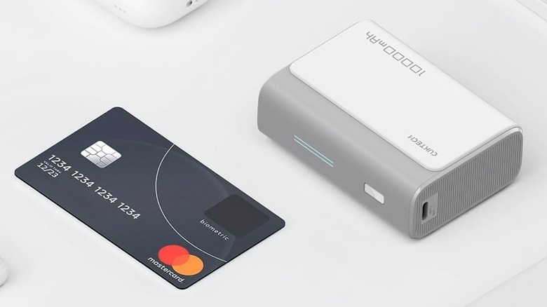 The CukTech 30W Mini Power Bank next to a credit card on a grey surface