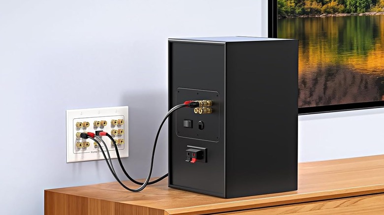 The Cable Matters Triple Gang 7.1 Speaker Wall Plate is connected to a bookshelf speaker.