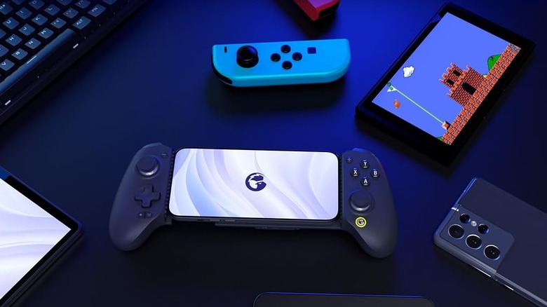 GameSir G8 Plus controller with a smartphone in it, as well as nintendo switch and other devices around it