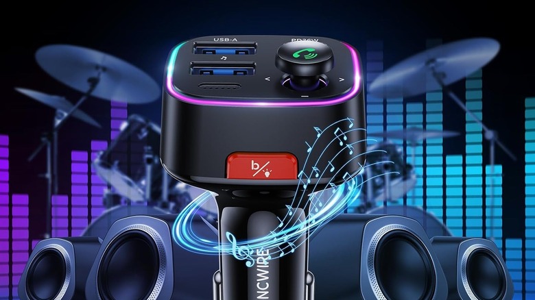 Close-up of Syncwire bluetooth fm transmitter concept in front of speaker system with music visualizer and drumset background