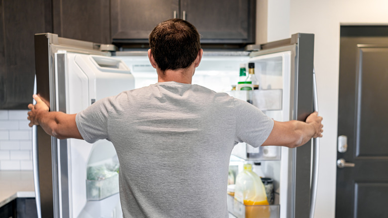person looking in fridge