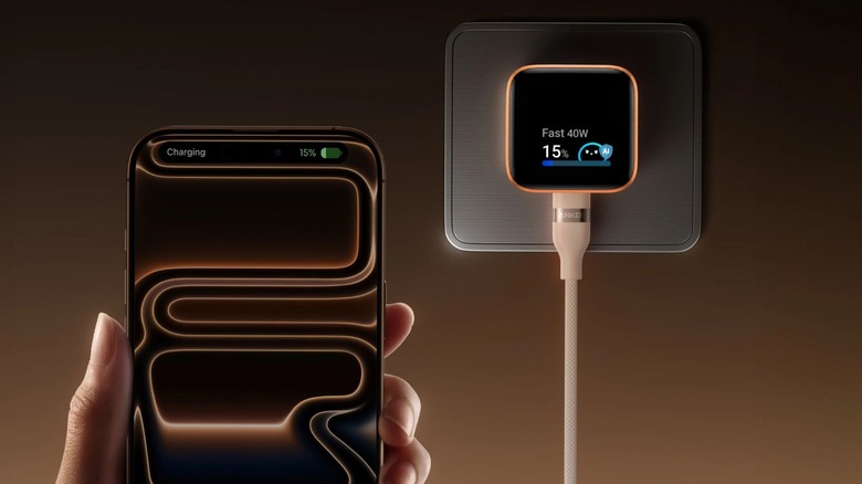 A hand holding an iPhone using an Anker Nano Charger