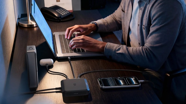 A person using an Anker Prime Charging Base