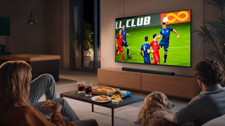 Family sitting on couch watching soccer on a Samsung QLED TV