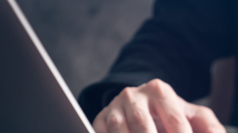 A man pluggin a USB-A device into a laptop