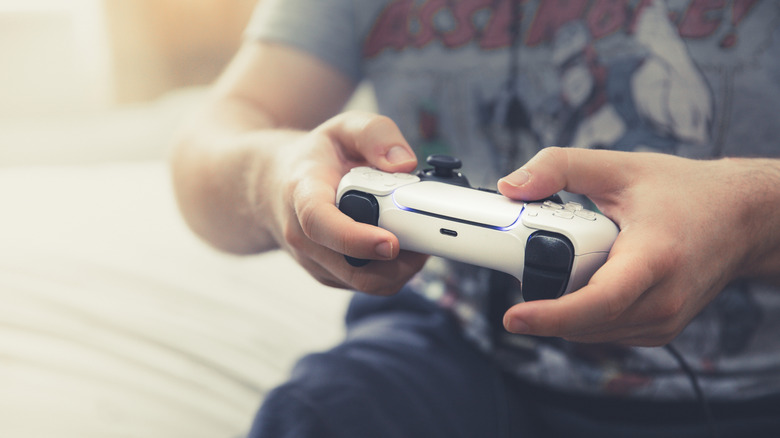 Close up of someone using a white PS5 controller