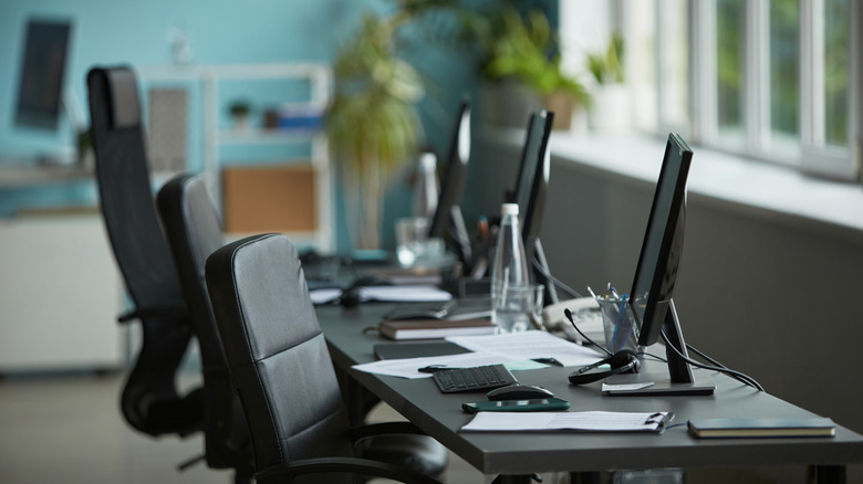An empty workplace, showing computer desks and chairs