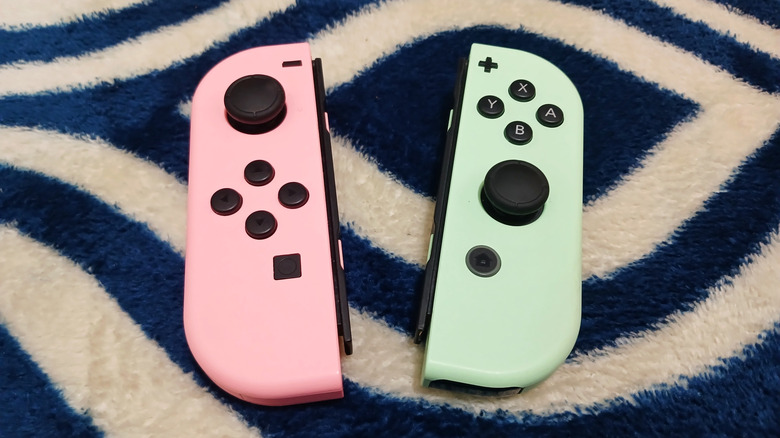 A pair of Nintendo Switch Joy-Cons on a carpet.
