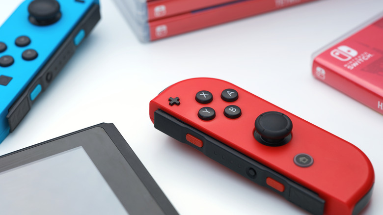 Disconnected Joy-Cons next to a Nintendo Switch and game boxes.