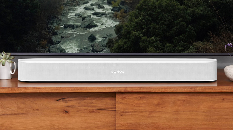 The Sonos Beam Gen 2 set up beneath a TV on a TV stand.