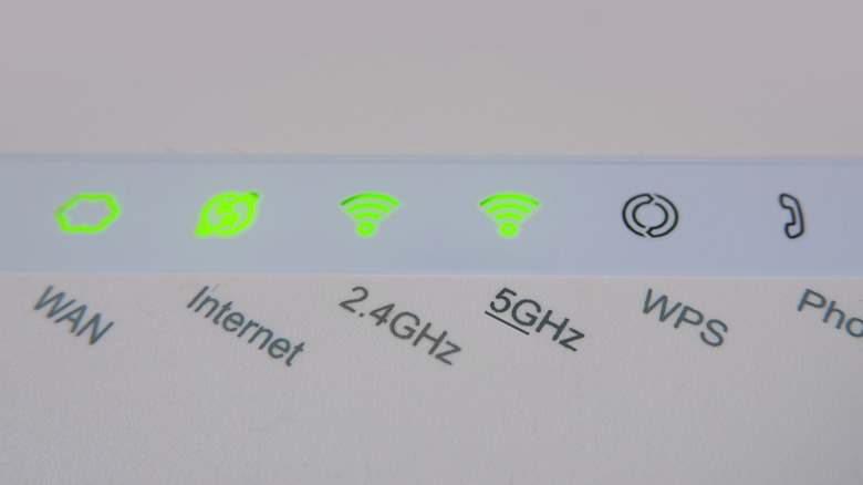 A bunch of LEDs on a router with their settings under them, focusing on the 2.4GHz and 5GHz network bands