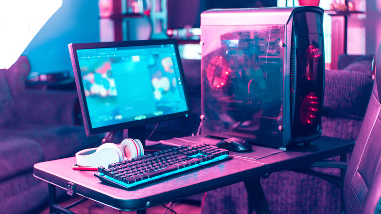 A gaming PC set up under a pink light
