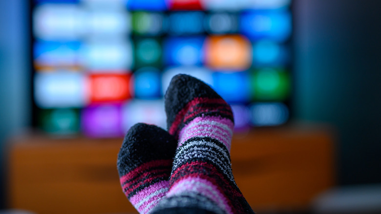 Close up of a woman's feet in front of a smart TV