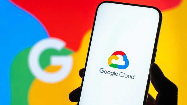 A person holding a smartphone showing the Google Cloud logo