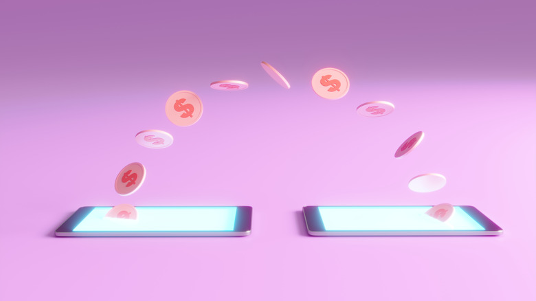money currency going from one phone to another on a purple-pink surface